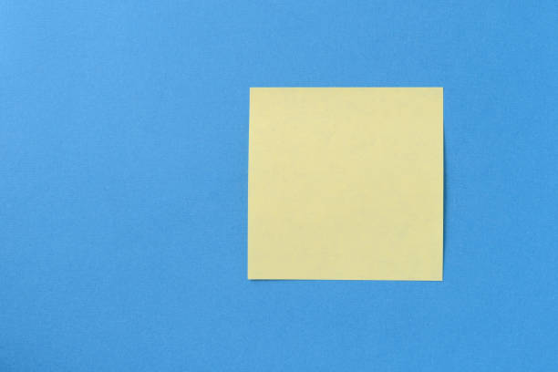istock Blank yellow sticker note on a blue background with copy space. Business concept, horizontal mock-up 1189682428