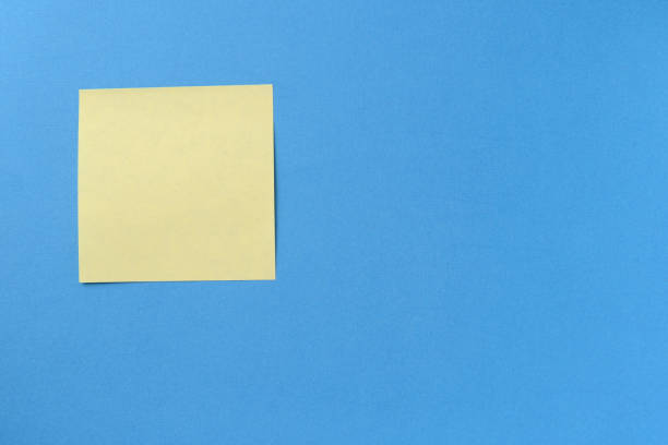 istock Blank yellow sticker note on a blue background with copy space. Business concept, horizontal mock-up 1189682429