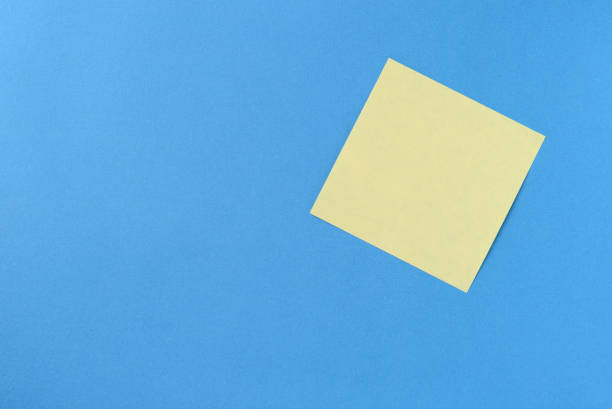 istock Blank yellow sticker note on a blue background with copy space. Business concept, horizontal mock-up 1189682432