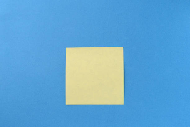 istock Blank yellow sticker note on a blue background with copy space. Business concept, horizontal mock-up 1189682434