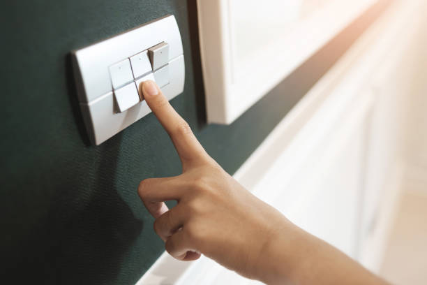 istock Female right hand is turning on switch. 1189684037