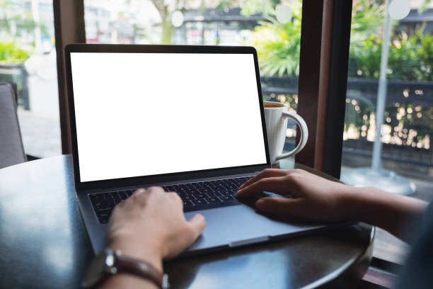 istock a woman using and typing on laptop with blank white desktop screen with coffee cup on the table 1189687503
