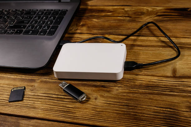 istock External HDD connected to laptop computer, SD memory card and USB flash drive on a wooden desk. Concept of data storage 1189696305
