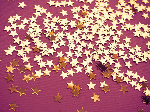 istock Golden stars glitter on lavender paper background 1189696347