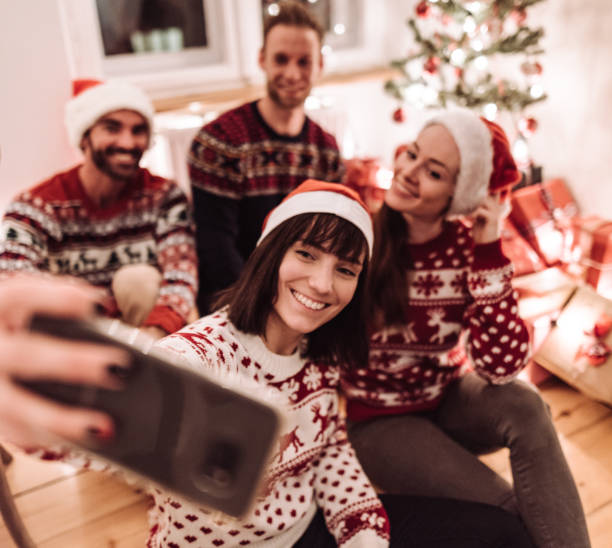 istock friends using smartphones at christmas 1189696578