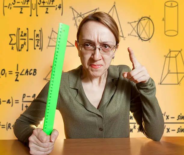 Photo of Mean female teacher holding ruler and pointing her finger