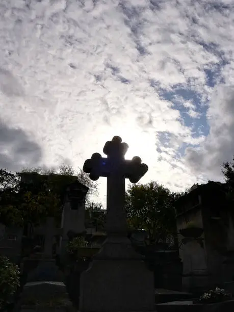 Photo of Cross, gravestone on the background of a dramatic sky. The concept of religion, sadness, mourning. Selective focus, copy space.