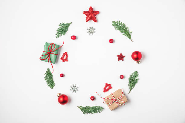 istock Christmas wreath made of fir tree branches, red decorations, gift boxes, pine cones on white background 1189699218