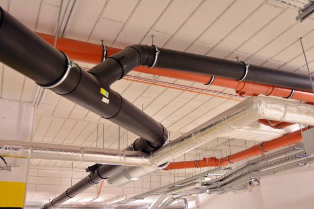 istock Water pipes and cable trays run under ceiling of a building 1189700716
