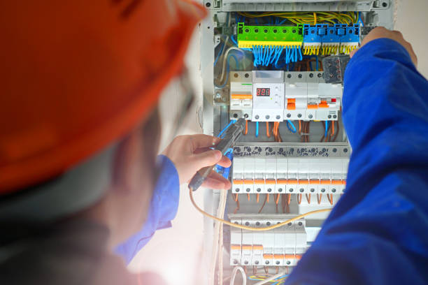 istock Electrician testing the electrical shield. Electrical switchboard with automats and wires. 1189700799