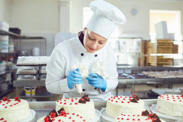 istock Confectioner with pastry cake in his hand at the bakery. 1189703834