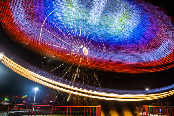 istock Two rides in motion in amusement park, night illumination. Long exposure. 1189705411