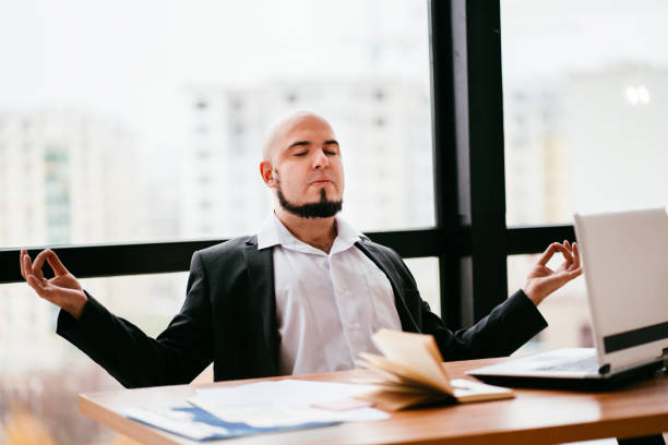 istock businessman meditating at office desk 1189706630