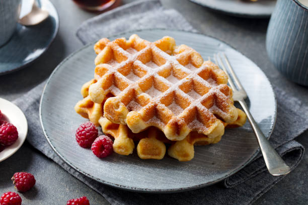 belgian waffles with maple syrup and fresh raspberry. grey background. close up. - baking traditional culture studio shot horizontal imagens e fotografias de stock