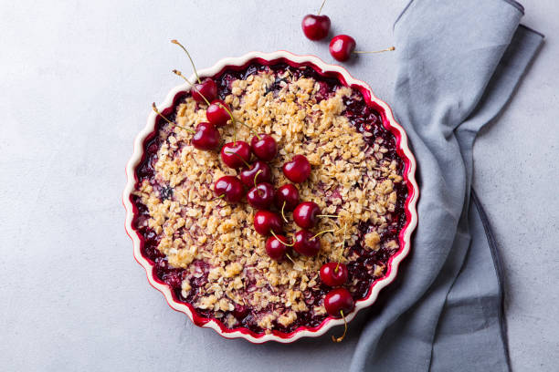 istock Cherry, red berry crumble in baking dish. Grey stone background. Top view. 1189708386