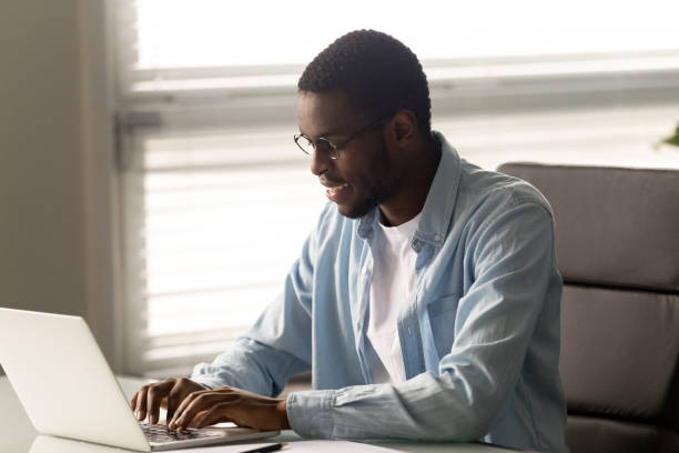 istock Smiling biracial male employee texting using laptop 1189709704