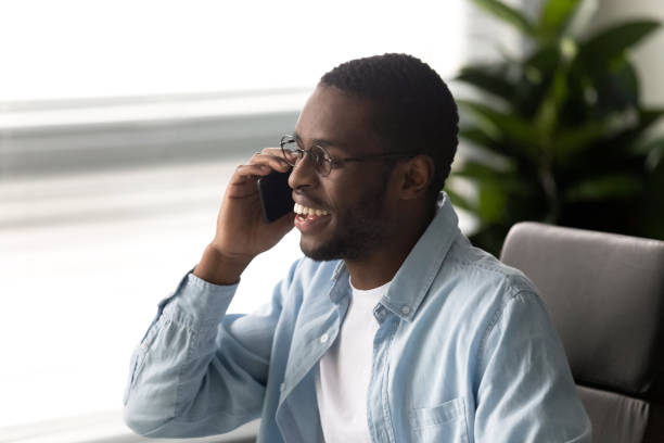 istock Smiling african American man having pleasant smartphone call 1189709722