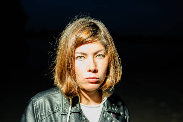 istock girl with a serious face in a leather jacket on a black background 1189713189