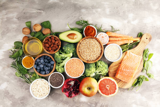 istock Healthy food clean eating selection: fish, fruit, vegetable, cereal, leaf vegetable on rustic background 1189713631