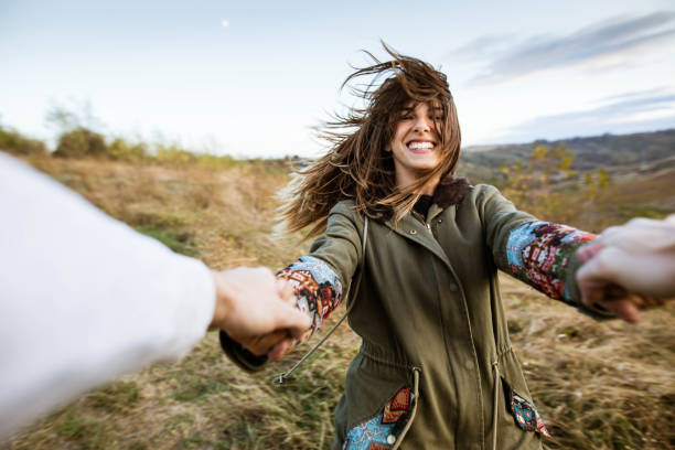 istock Cheerful woman having fun while spinning with her boyfriend in nature. 1189715099