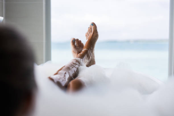 pies de mujer irreconocibles en el baño de burbujas. - bathtub women bathroom relaxation fotografías e imágenes de stock