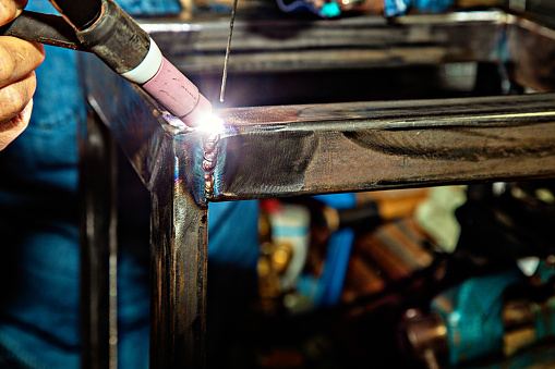 Female TIG welder welding steel