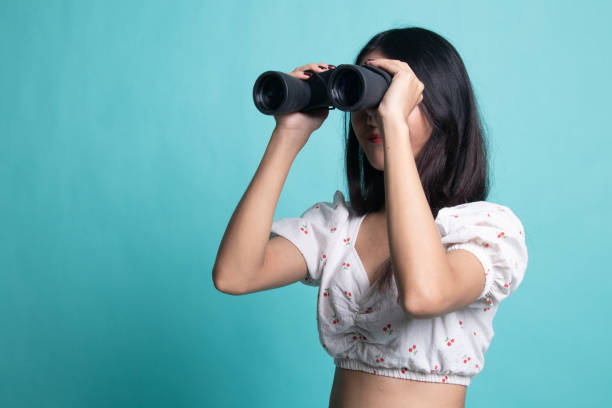 istock Young Asian woman with binoculars 1189717893