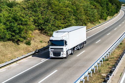 White Transportation Truck on summer country highway on a bright day