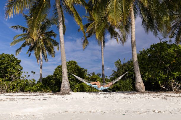 istock Young happy woman enjoying in hammock on the beach. 1189720162
