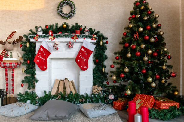 istock decorated white fireplace with socks and Christmas tree with gifts 1189722468