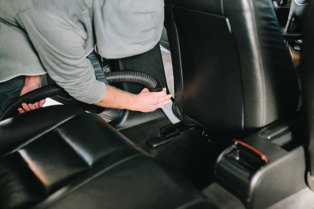 istock Man cleans car interior with vacuum cleaner 1189723308