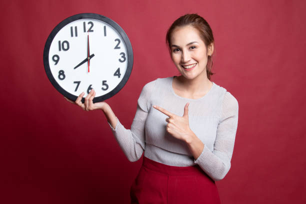 istock Young Asian woman point to a clock. 1189723821