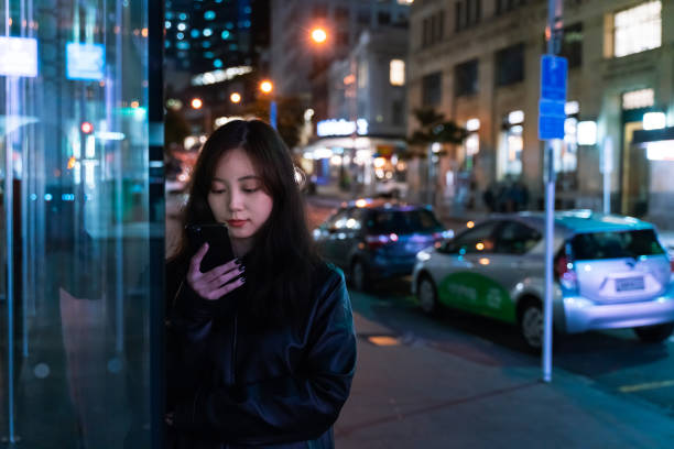 istock Young asian using smartphone at night Social Connecting in smart city 1189725567