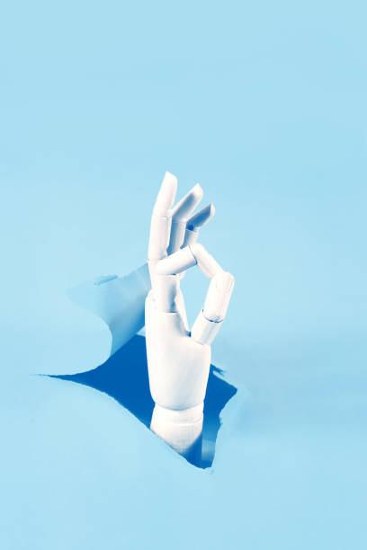 istock Hand through the hole in paper 1189729220