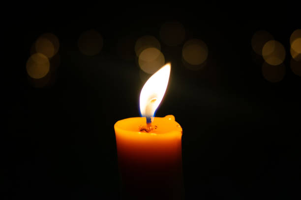 istock One light candle burning brightly in the black background 1189730145