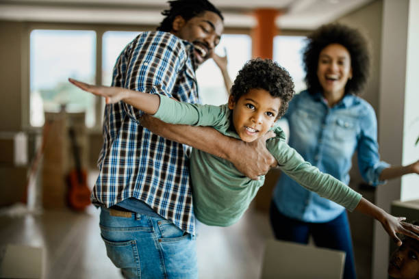 istock Happy black boy having fun while playing with his father at home. 1189731181