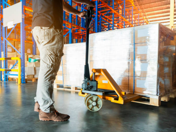 istock warehouse worker with hand pallet truck unloading cargo pallet shipment at warehouse 1189732902