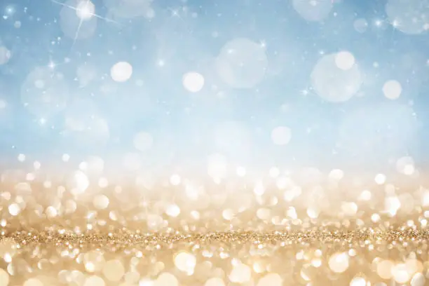 Abstract defocused gold and blue glitter background with copy space