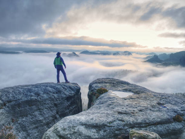 istock Hike in autumn mountains. Man stay above heavy mist in valley 1189736727
