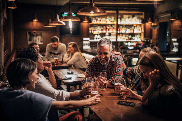 Group of friends having fun while drinking beer in pub