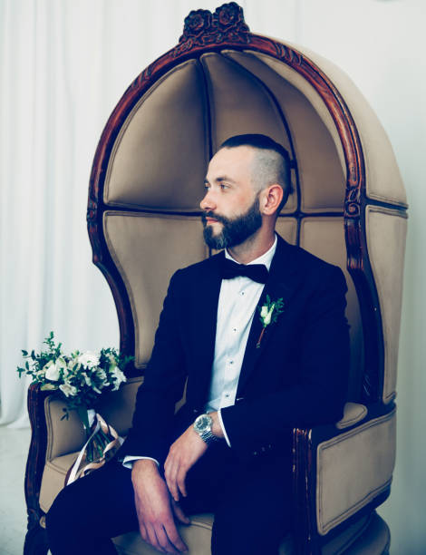istock brooding groom waiting for his bride sitting in a chair 1189738057