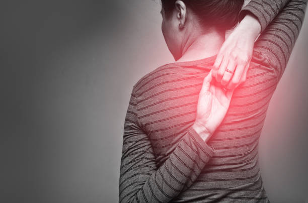 istock Asian woman exercising for shoulder stretching. Eagle Arms Asana. Posing for shoulder flexibility to relieve symptom of office syndrome. Black and white tone with red spot on woman's back 1189738250