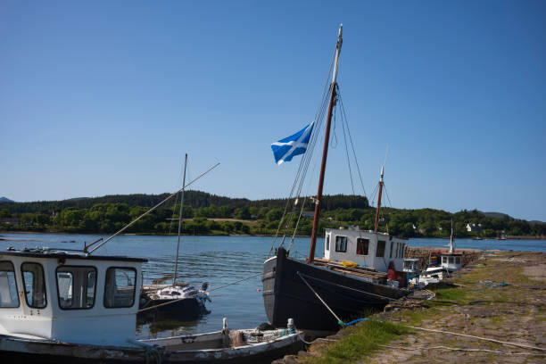 A fleet of old, wooden, fishing vessels docked on a pier along Broadford Bay in Broadford, Isle of Skye, Scotland, United Kingdom. A fleet of old, wooden, fishing vessels docked on a pier along Broadford Bay in Broadford, Isle of Skye, Scotland, United Kingdom. isle of skye broadford stock pictures, royalty-free photos & images