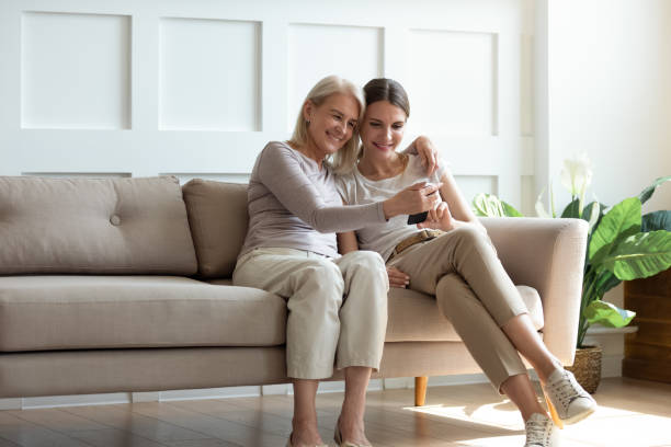 istock Happy 2 female generations sitting on sofa, enjoying free time. 1189748800