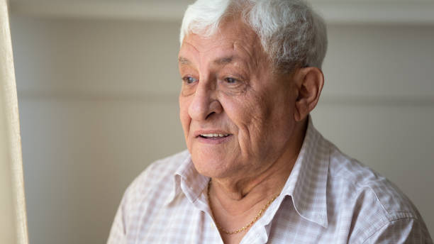 istock Happy older retired man looking with hope out of window. 1189748851