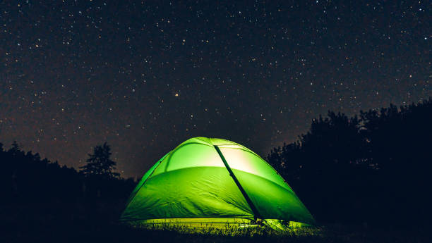 istock Milky way in the forest landscape affect the viewer's imagination, dense virgin forests on the slopes contribute to conceal the traces of civilization, illuminated Tent 1189753716