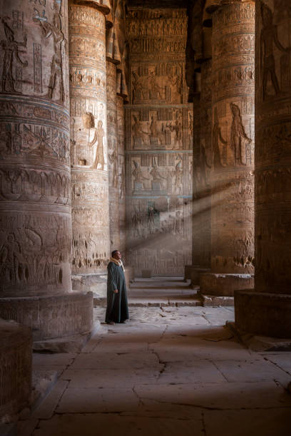 An Egyptian temple watcher Abydos, Egypt - November 07, 2018 :  the temple watcher becomes a model for the tourist photographer. abydos stock pictures, royalty-free photos & images