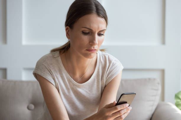 istock Thoughtful young woman looking at cellphone screen. 1189755053