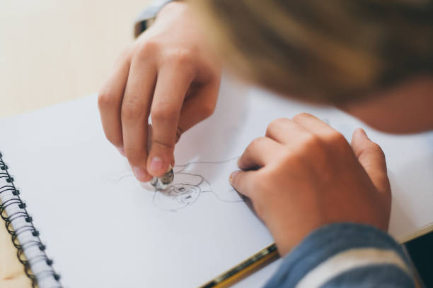 Close up view of student drawing with pencil. Boy doing homework writing on a paper. Kid hold a pencil and draw a manga at home. Teen drawing sitting at the table. Education art talent ability concept vista de cerca del dibujo de los alumnos con lápiz. chico haciendo los deberes escribiendo en un papel. el niño sostiene un lápiz y dibuja un manga en casa. dibujo adolescente sentado en la mesa. concepto de habilidad de talento de arte educativo