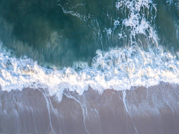 istock Drone picture of waves hitting the beach. 1189759137